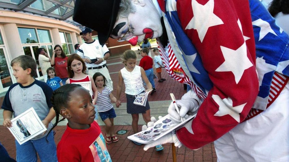 Uncle Sam the clown autographs his photo on the Shrine Circus program cover for Jaquez Crocker before the performance in 2004 at the Columbus Civic Center. The show returns to Columbus on Saturday and Sunday.