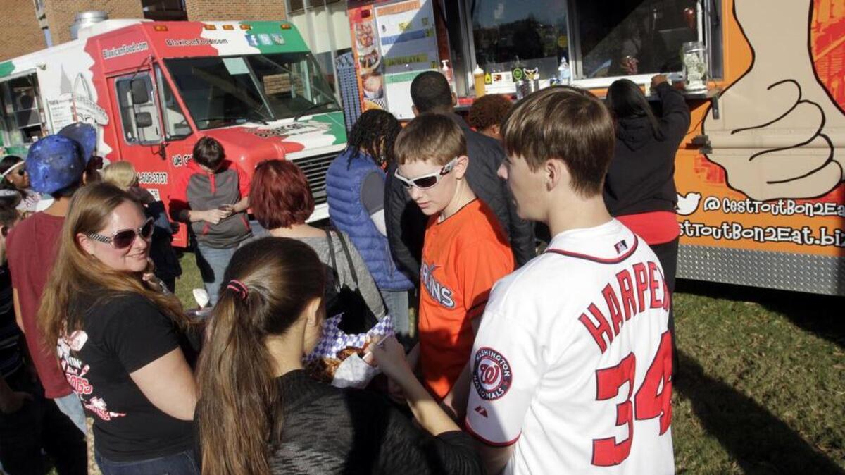Friends wait for their food order from one of the several food trucks at the Uptown Food Truck Festival at Woodruff Park on Nov. 14, 2015.