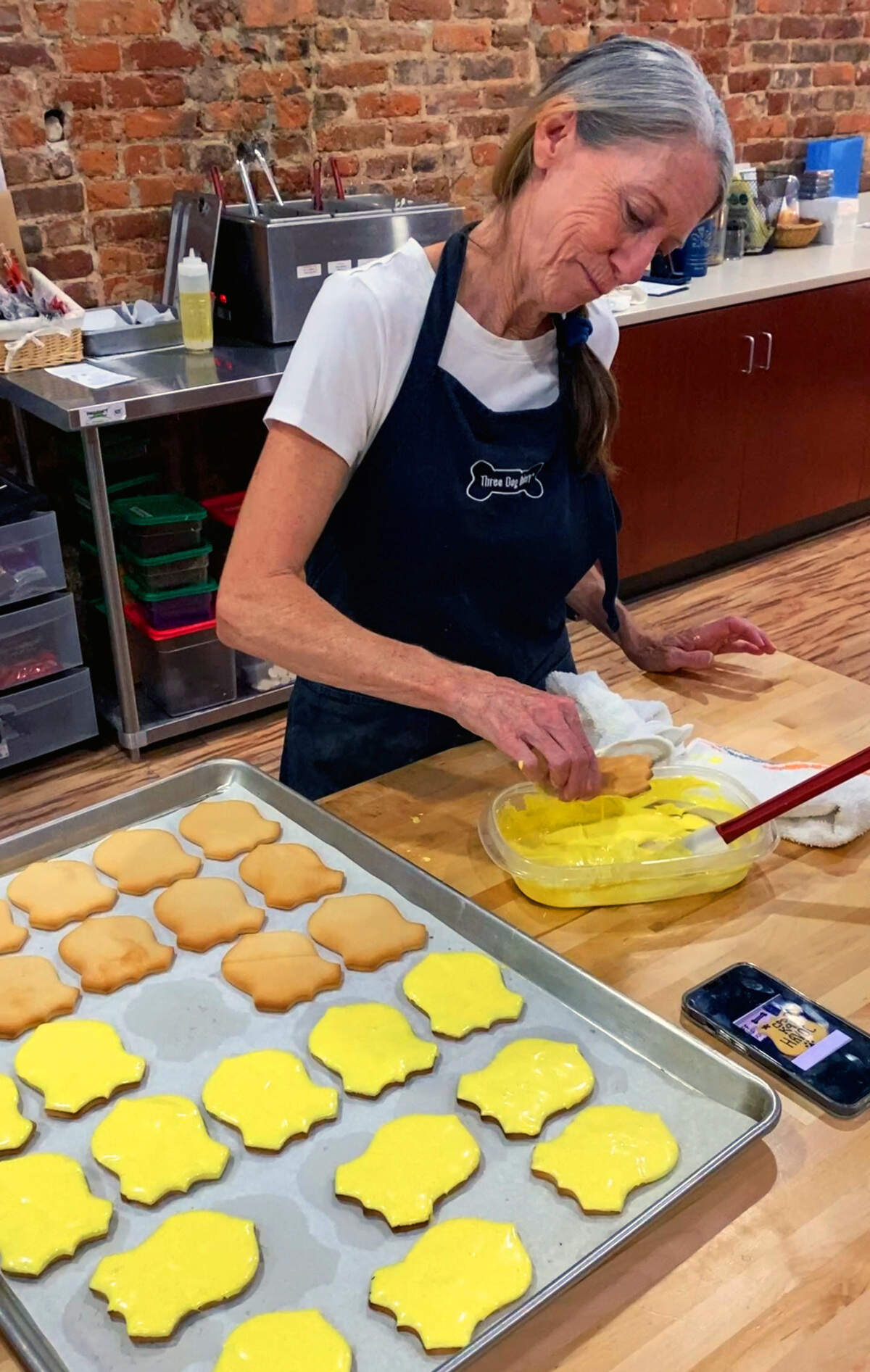 Tracy St. John makes a K9 Havoc badge cookie Thursday morning. Beginning June 26, 2026, Three Dog Bakery in Columbus is selling K9 Havoc badge cookies to raise money to support Havoc’s recovery. Each cookie costs $5, and all money goes to support Havoc, who was wounded during an officer-involved shooting of a homicide suspect this week.