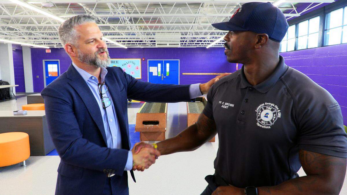 Chris Woodruff, president of The Cotton Companies, left, talks with Courtney Brown from Columbus Fire & EMS recently at the J. Barnett Woodruff Boys & Girls Club in Columbus, Georgia.
