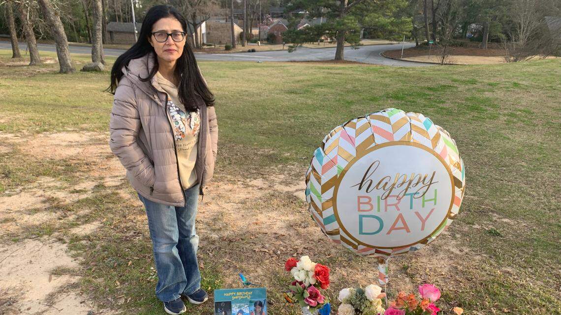 Rebecca Lara stands next to a memorial dedicated to her daughter Gisele Lara who was killed in an apparent murder-suicide on the campus of Columbus State University.