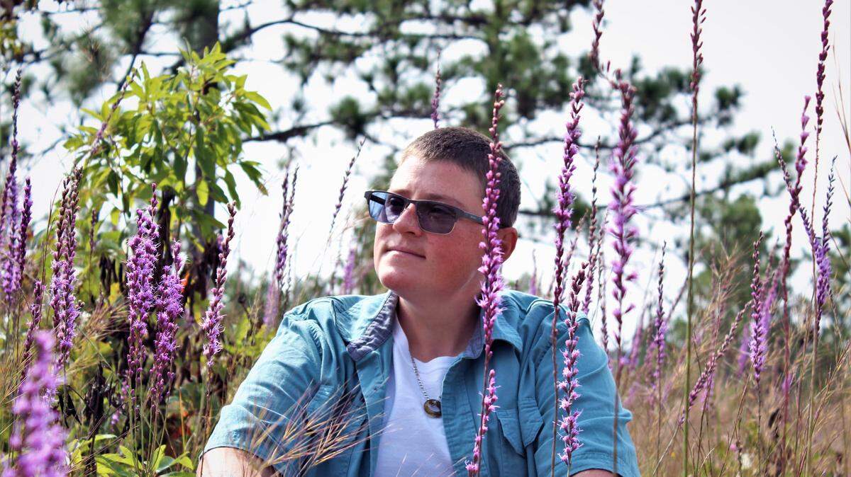 Ashley Desensi sits among a superbloom of (liatris) blazingstar at the Canoochee Sandhills