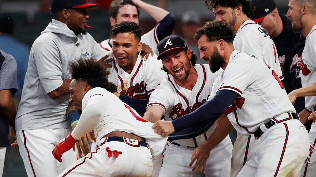 Atlanta Braves second baseman Ozzie Albies (1) is mobbed by his teammates after hitting a walk-off home run in the 11th inning of a baseball game against the Cincinnati Reds, Tuesday, June 26, 2018, in Atlanta