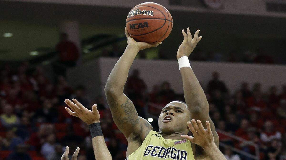 GERRY BROOME/Associated PressGeorgia Tech's Marcus Georges-Hunt shoots over North Carolina State's BeeJay Anya and Caleb Martin during the second half Wednesday in Raleigh, N.C., Wednesday. Georgia Tech won 90-83.