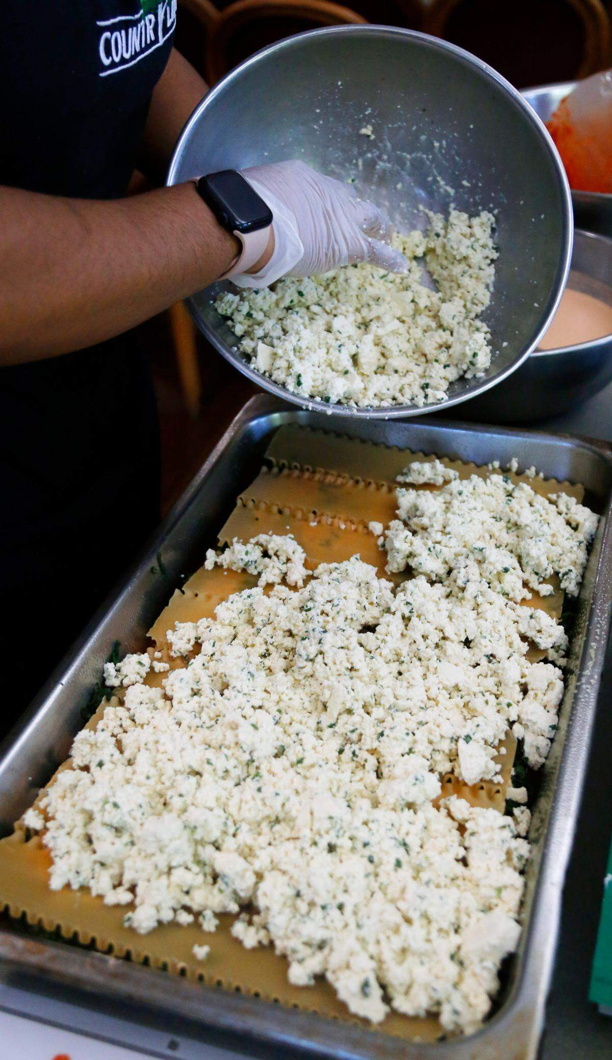 Terriann White, the kitchen supervisor at Country Life in Columbus, adds the tofu mixture to a pan of their vegan lasagna recipe. 05/05/2025