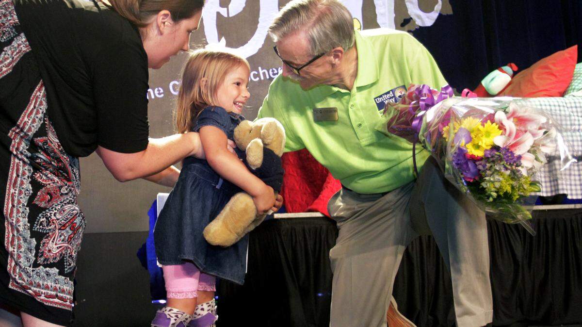 ROBIN TRIMARCHI rtrimarchi@ledger-enquirer.comScott Ferguson, president and CEO of the United Way of the Chattahoochee Valley, brings a bouquet of flowers to Kendall Barfield, 4, and her mother Danielle Barfield to end the 2015 United Way Campaign Kickoff luncheon Thursday at the Columbus Convention & Trade Center. Barfield spoke to the audience on behalf of Easter Seals. Kendall was born with spina bifida, and the Barfields were told by doctors that she would never walk. The playful youngster took to the stage looking for familiar faces in the audience, and at one point tossed aside her crutches to take a few steps unassisted. The 2015 campaign goal is to raise $7.11 million.  08.27.15