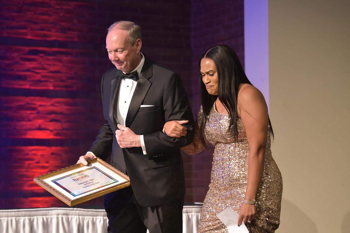 David Lewis, superintendent of the Muscogee County School District, escorts Vanessa Ellis, a teacher at Veterans Memorial Middle School, onto the stage after she was named the 2022 MCSD Teacher of the Year Thursday evening at the Columbus Convention and Trade Center in Columbus, Georgia. 05/05/2022
