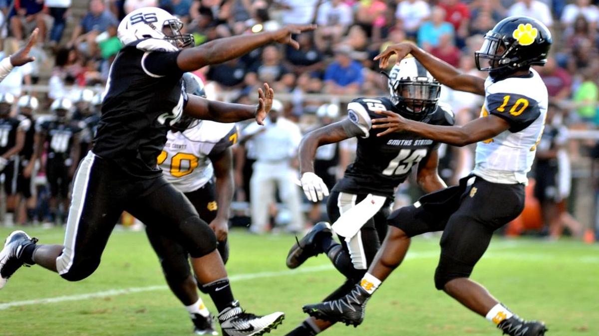 Smith Station's Deondrae Williams (left) and Kenyonte Hudson pass rush Harris County's Jordan Griffin, forcing an incomplete pass early in the 1st quarter of the game Friday night August 19, 2016