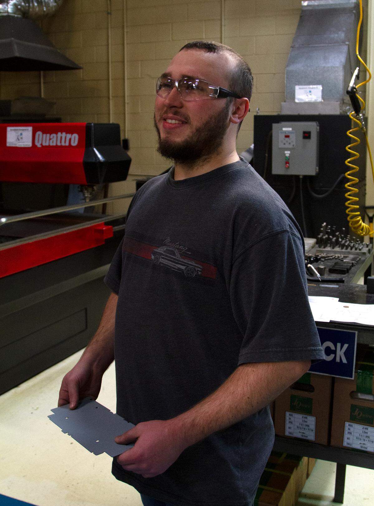 Aaron Henderson, a Columbus Technical College student apprenticing at Oneda, smiles while holding a piece of metal he just worked on with a laser on Wednesday, April 10, 2019, in Columbus, Ga. 