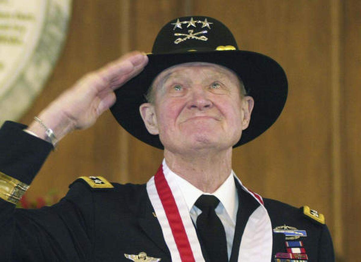 FILE - In this Thursday, Jan. 29, 2004 file photo, retired Lt. Gen. Hal Moore, of Auburn, Ala., salutes the crowd during a standing ovation at the state capitol during the Spirit of Alabama Awards in Montgomery, Ala. Moore, co-author of “We Were Soldiers,” was one of several recipients of the award, created by Gov. Bob Riley. On Friday, Feb. 10, 2016, Moore, known for saving most of his men in the first major battle between the U.S. and North Vietnamese armies, died. He was 94. (AP Photo/Jamie Martin)