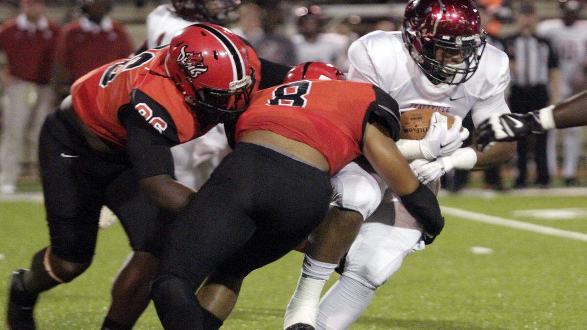ROBIN TRIMARCHI rtrimarchi@ledger-enquirer.com 
 Central High defensive lineman Deandre Ivey (96) and linebacker Markail Benton (8) hit Prattville running back Kingston Davis in first half action at Garrett-Harrison Friday. 09.18.15