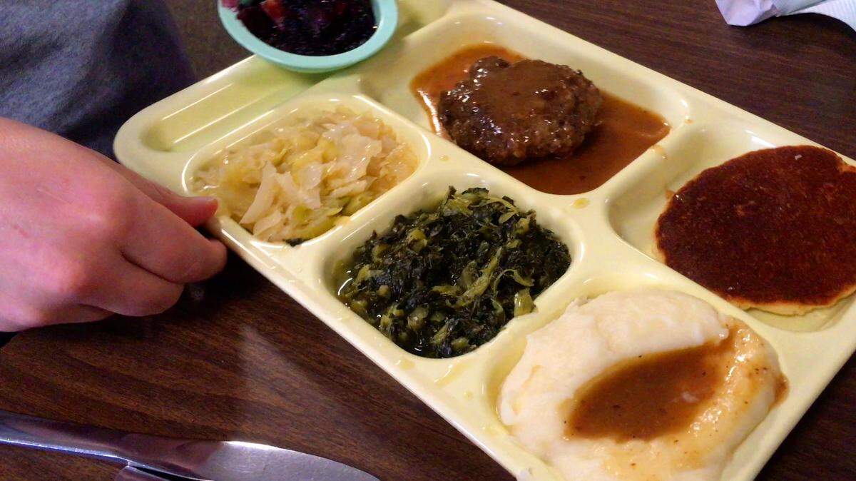 This photo from the Ledger-Enquirer’s 2020 visit to the Royal Cafe in Columbus shows the hamburger steak, fresh mustard greens, steamed cabbage, cream potatoes and blackberry cobbler.