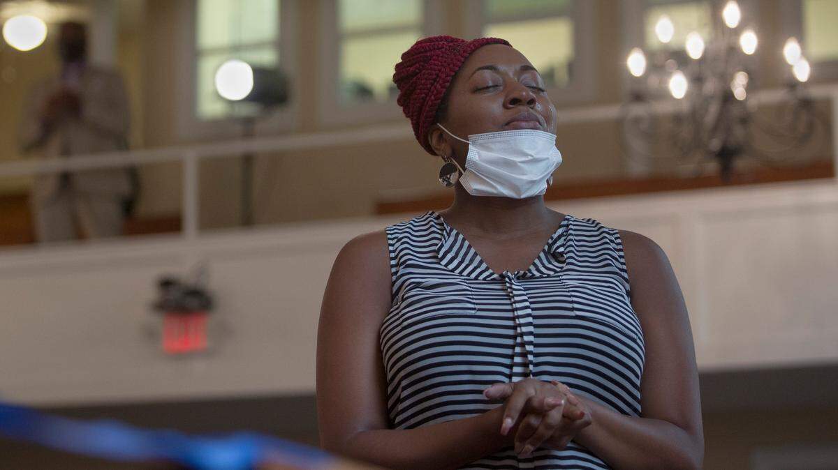 A congregant listens to prayer from Reverend Reggie Williams at South Columbus United Methodist Church on June 20, 2021.
