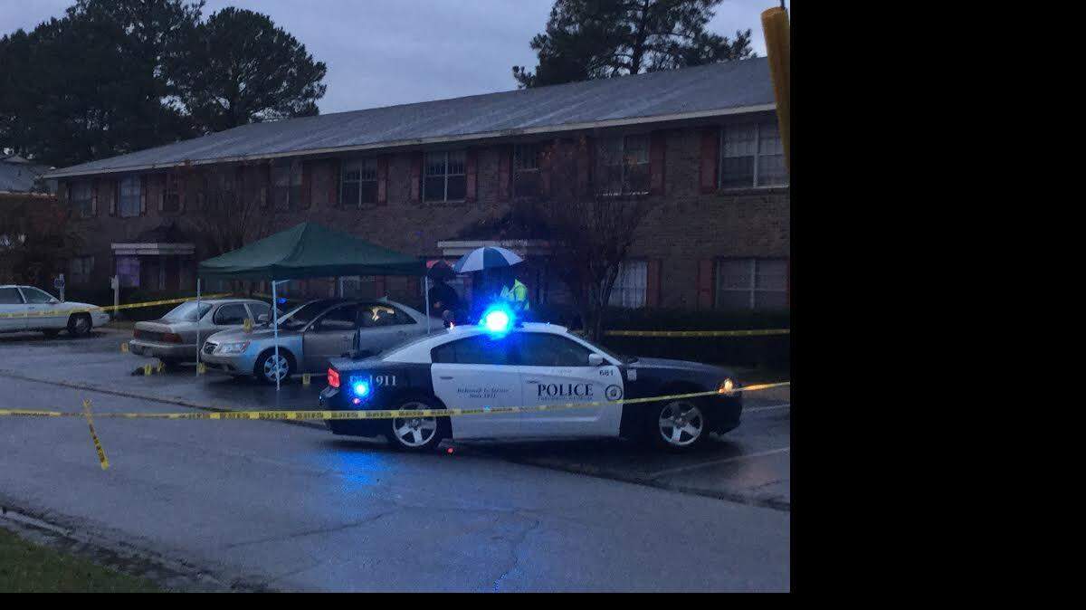 Police use a cover to investigate car where man was shot to death Wednesday.