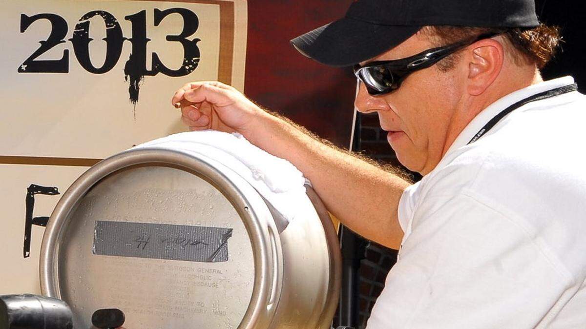 Brian Waters taps a keg for the opening ceremony of the 2013 Uptown Wine and Beer Festival in Columbus.