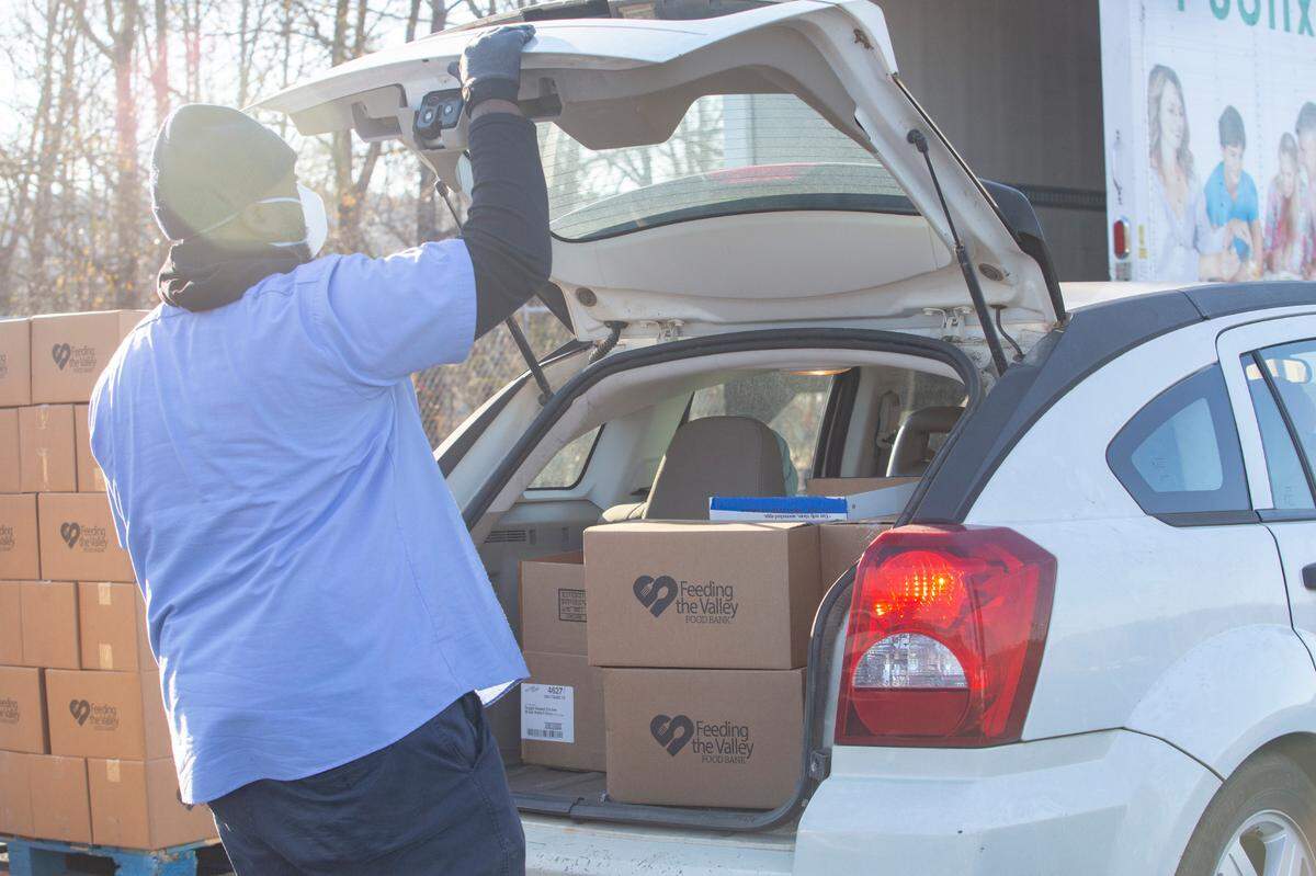 Feeding the Valley employee Louis Perry loads groceries into a car at a mobile food pantry site in Hamilton, Ga. on Jan. 27, 2022.