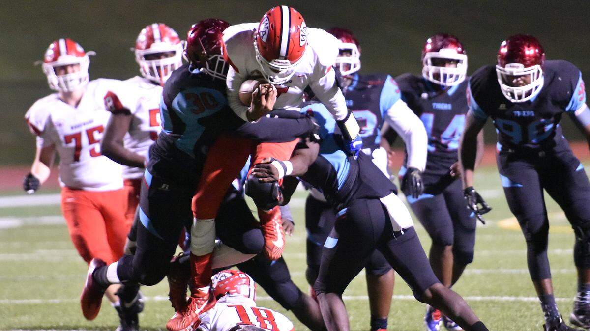 Carver’s A’hjoni Crowell and Keshawn Washington combine on the tackle of Woodward Academy’s Mike Wright for no gain on the play in the second quarter for the GHSA Class AAAA first-round state playoff game Friday night, November 9, 2018, at Kinnett Stadium.