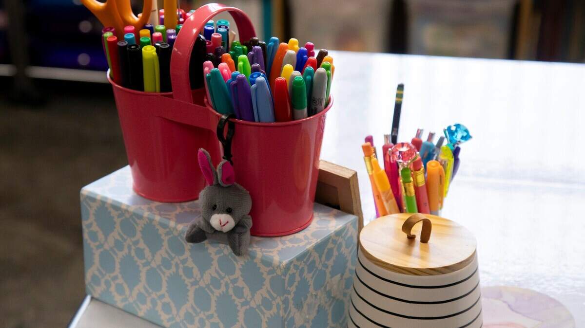 Pens, markers, and other writing utensils held in plastic cups.