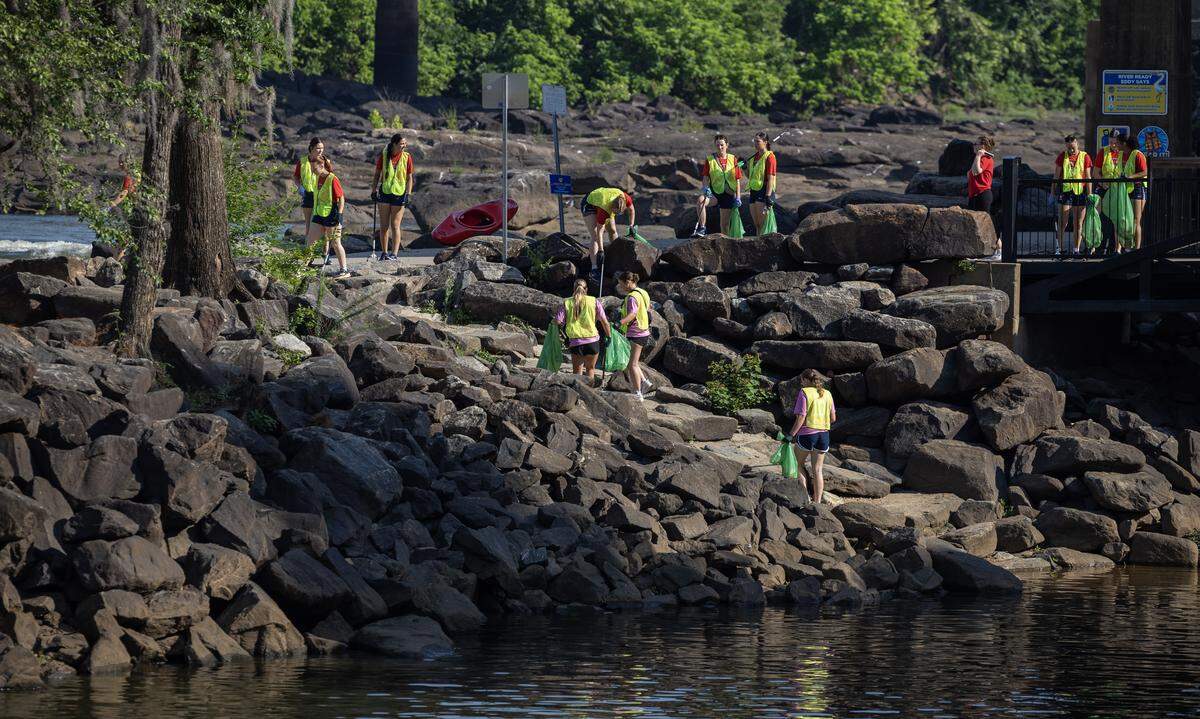 College softball players in Columbus for the 2026 NAIA Softball World Series swapped their softball gloves for disposable gloves May 20, 2026, to beautify the Chattahoochee Riverwalk. Players and coaches from two schools, the University of the Cumberlands in Williamsburg, Kentucky, and Marian University in Indianapolis scoured the Riverwalk for trash, debris and litter as part of the Champions of Character Cleanup effort organized by the Keep Columbus Beautiful Commission and the Columbus Sports Council.