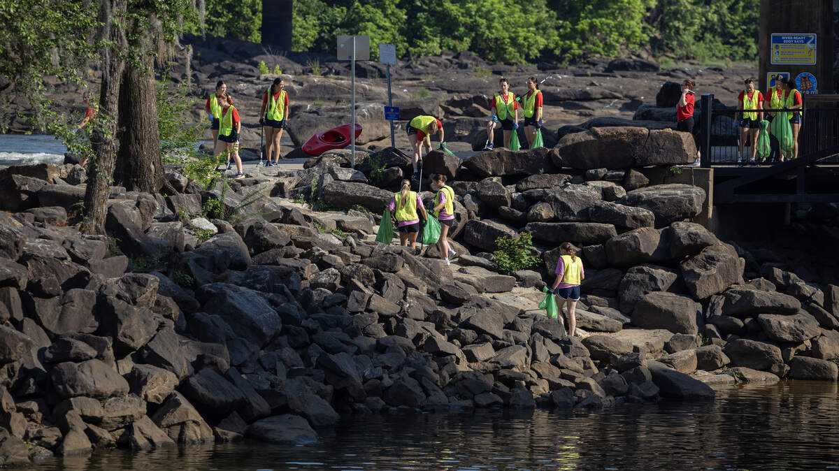 College softball players in Columbus for the 2026 NAIA Softball World Series swapped their softball gloves for disposable gloves May 20, 2026, to beautify the Chattahoochee Riverwalk. 