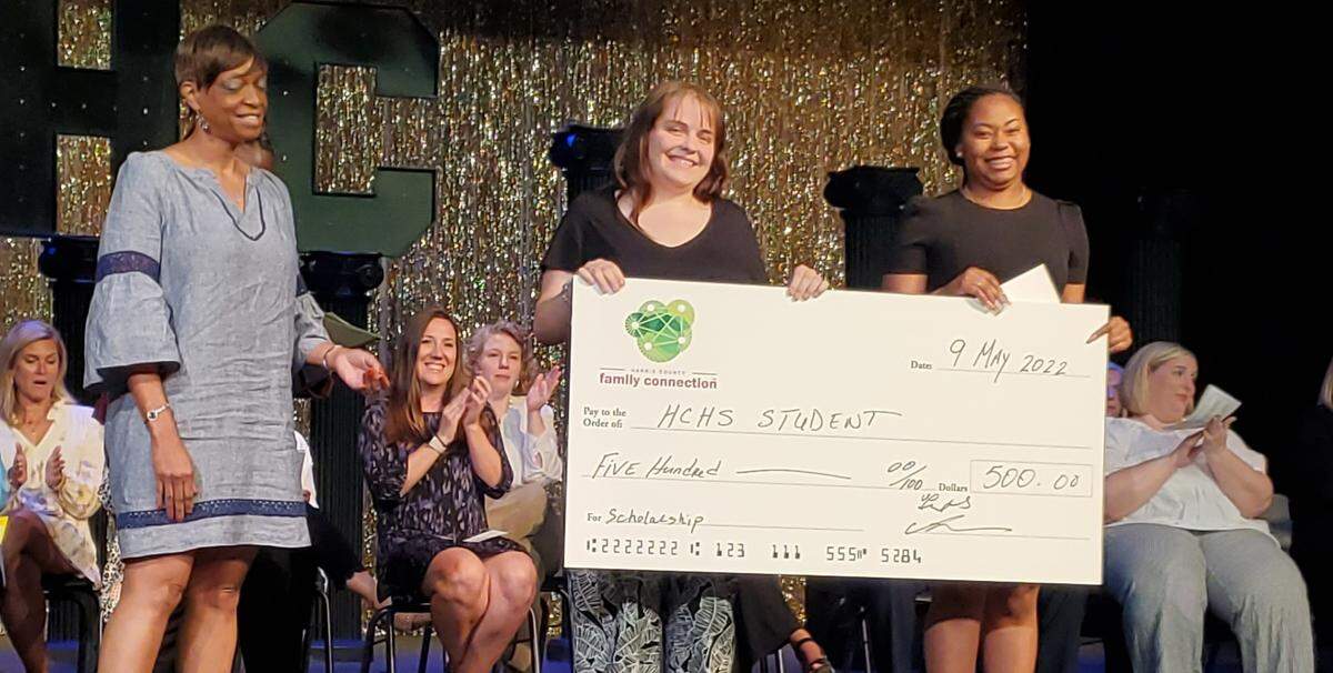 Kellie Finnegan, center, receives a $500 college scholarship from Harris County Family Connections during the Harris County High School senior awards ceremony May 9, 2022.