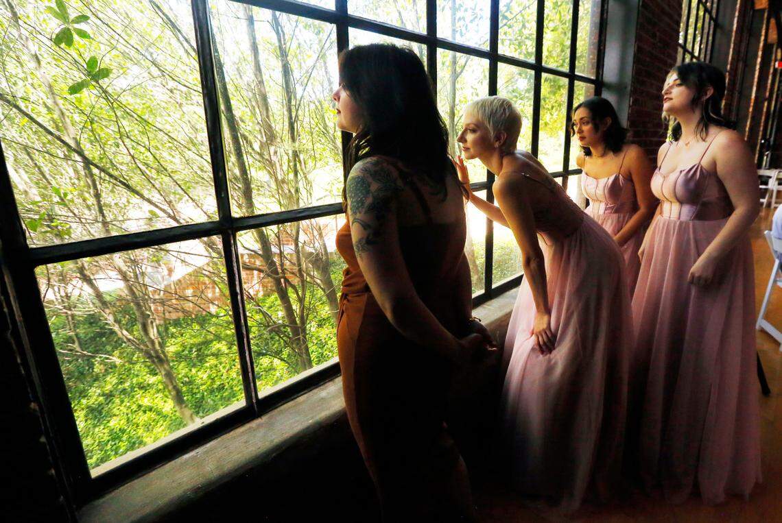 From left, Rebecca Gossett, Maddie Tweed, Leila Wheaton, and Chelle Leary, peer out the window while waiting to called for a scene after being selected as extras for a scene being filmed Monday at the Bibb Mill Event Center for the movie “Razor’s Edge” in Columbus, Georgia. 07/10/2024