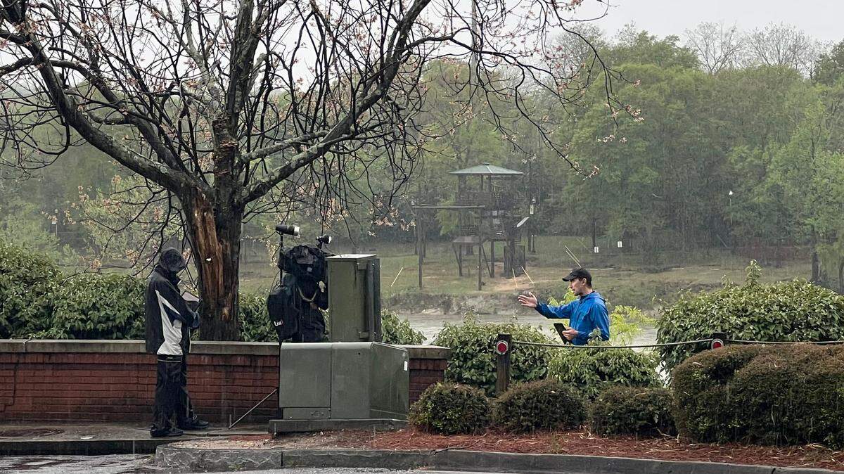 Weather Channel meteorologist Chris Bruin broadcasts live at the Riverwalk in Columbus Tuesday as the city endures severe weather.