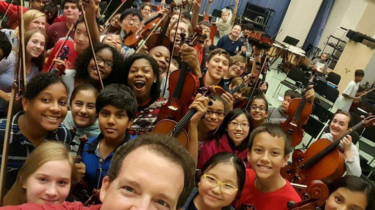Special to the Ledger-EnquirerJim Palmer, music director and conductor for the Youth Orchestra of Greater Columbus, poses with young musicians as part of an "unselfie" contest for Georgia Gives Day.