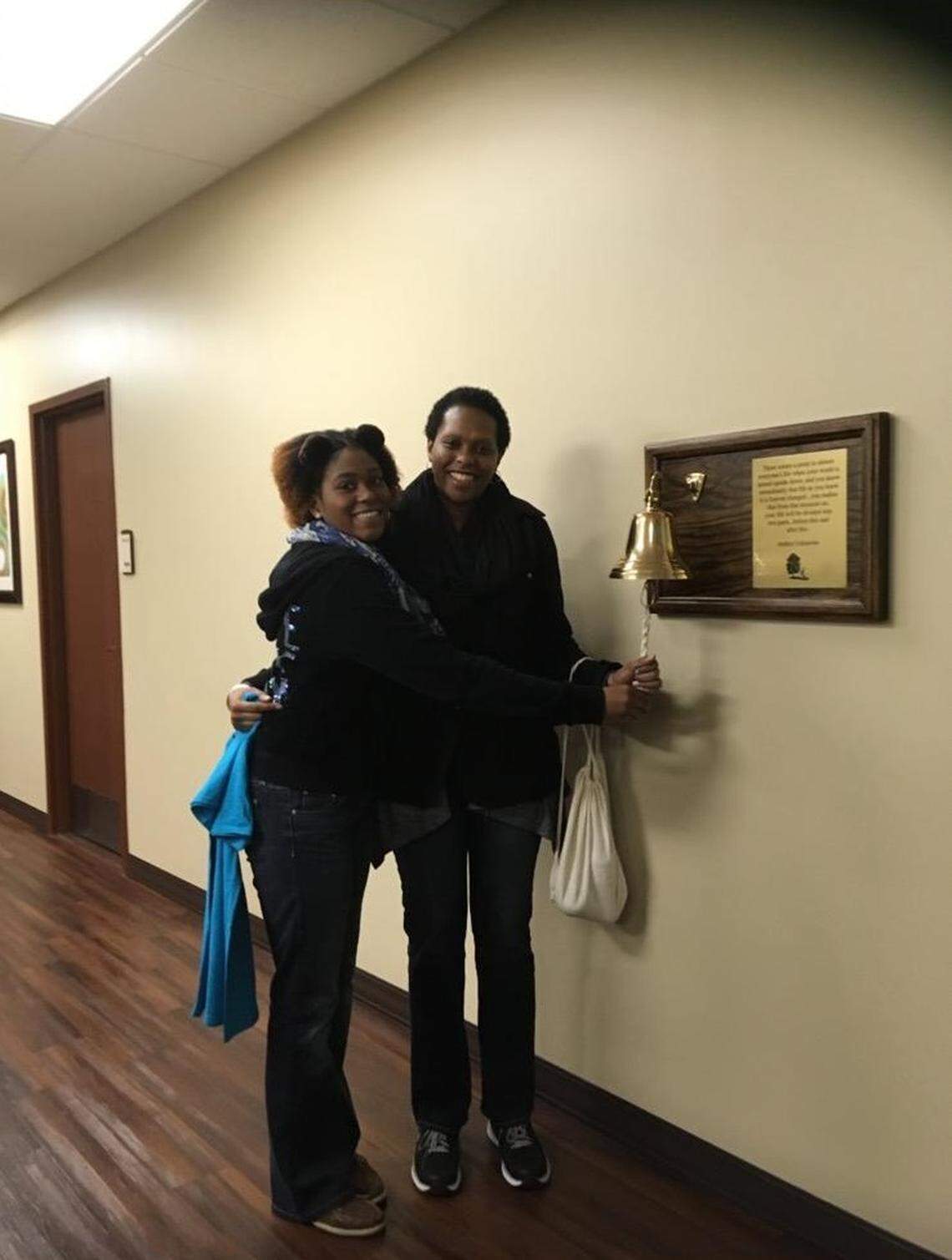 Sheila Middleton (right) celebrates with her daughter, Kadeah Tolbert (left), as she rings the bell indicating that she has completed radiation therapy.