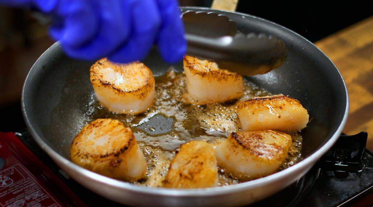 Chef Trevor Morris teaches Ledger-Enquirer reporter Sundi Rose how to cook scallops for a dish featuring risotto and scallops at Trevioli Italian Kitchen at the Rapids in downtown Columbus, Georgia. 05/29/2024
