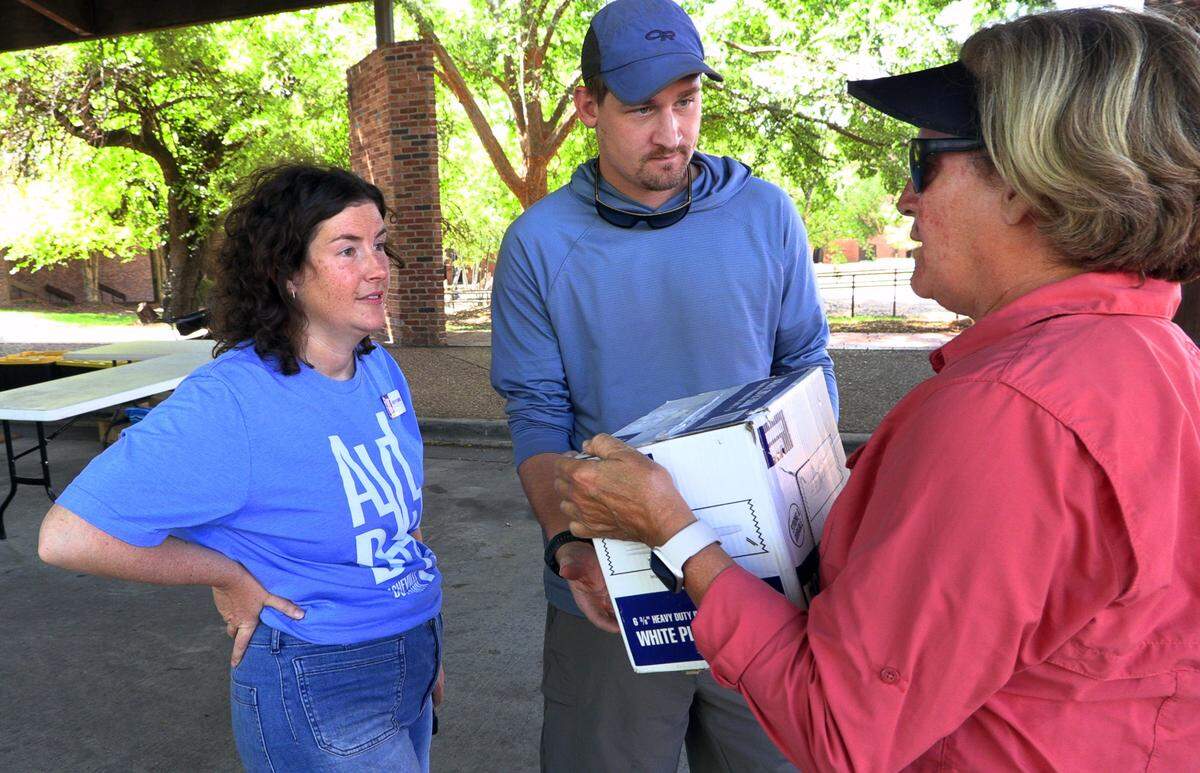 Columbus resident Dorris Bishop, right, speaks with Hayden and Tim Plemmons on Tuesday at the Columbus, Convention & Trade Center. Bishop and her husband Richard were dropping off water and other supplies to be taken to Asheville, North Carolina. Hayden Plemmons is the executive director of Asheville Downtown Association and originally from the Columbus area. 10/01/2024