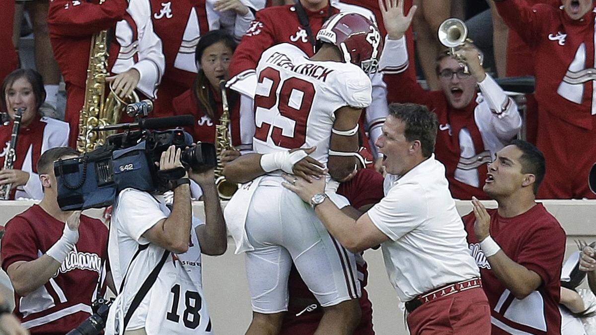 Alabama defensive back Minkah Fitzpatrick (29) celebrates with fans and the band after he returned an interception for a touchdown against Texas A&M during the second half of an NCAA college football game, Saturday, Oct. 17, 2015, in College Station, Texas. Alabama won 41-23. (AP Photo/Eric Gay)