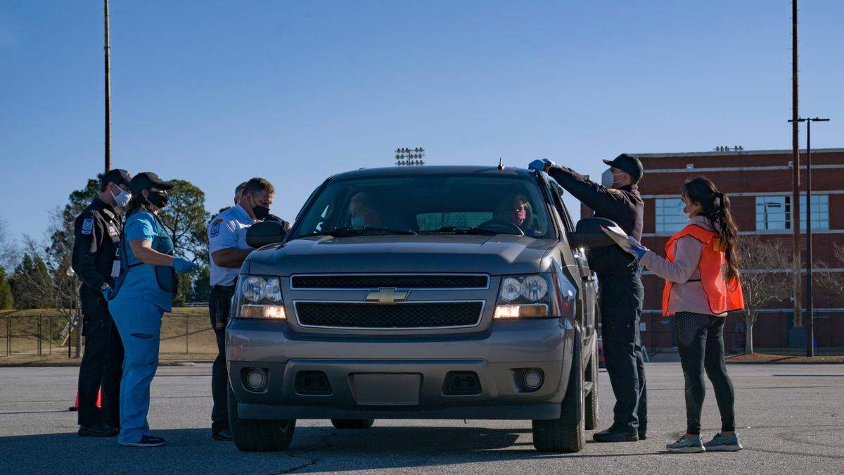 A crew of vaccinators greet a new recipient at the Civic Center in Columbus, Ga. on Saturday, Jan. 23, 2021.