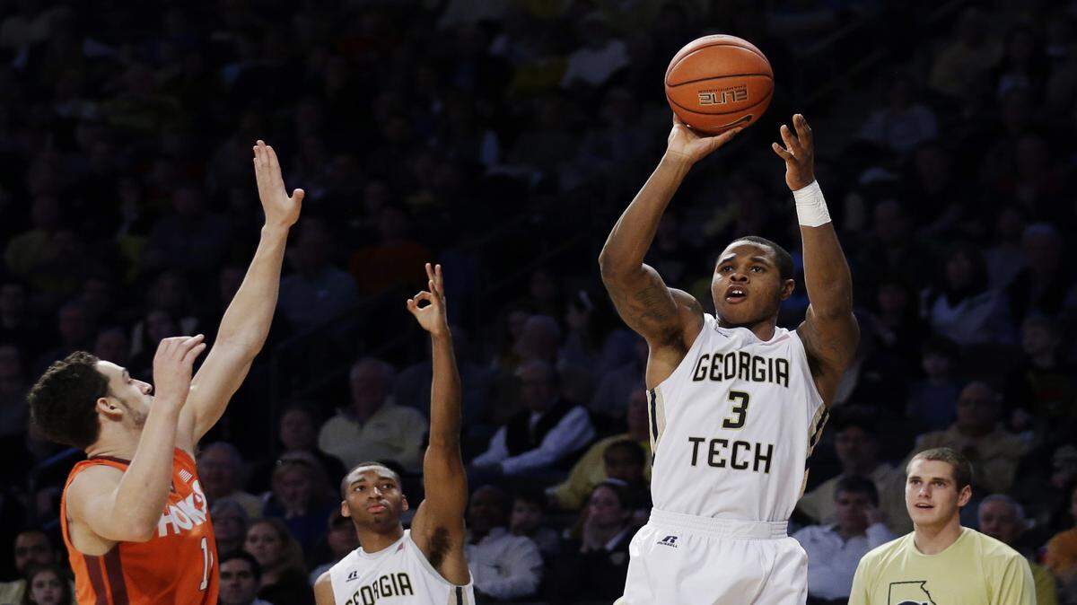 DAVID GOLDMAN/Associated PressGeorgia Tech's Marcus Georges-Hunt, right, hits a three-point basket in front of Virginia Tech's Devin Wilson, left, in the second half Jan. 16 in Atlanta. Virginia Tech won 78-77.