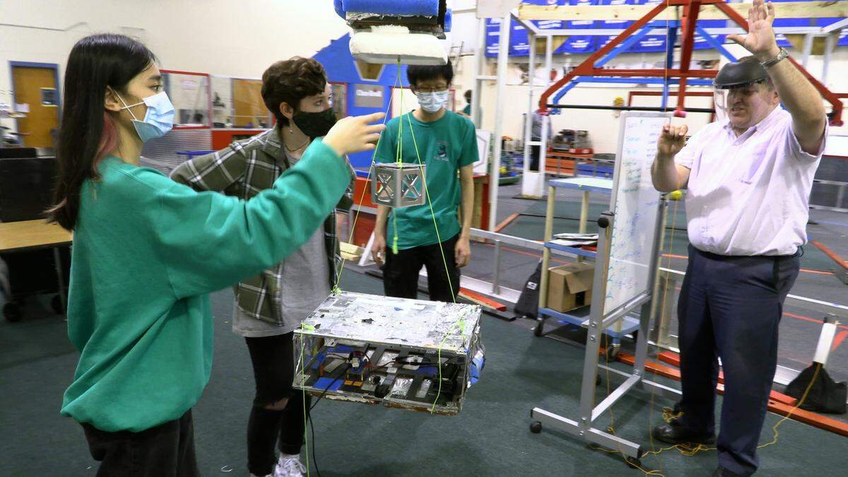Luther Richardson,right, who teaches physics and computer science at Columbus High School and is the program manager for the Columbus Space Program, works on a satellite project with CHS students, from left, Michelle Pham, Cora Wilcox, and Ray Toma