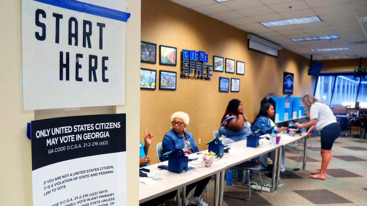 Poll workers wait to assist voters at Columbus Technical College in Columbus, Georgia on Friday morning during the final day of early voting.