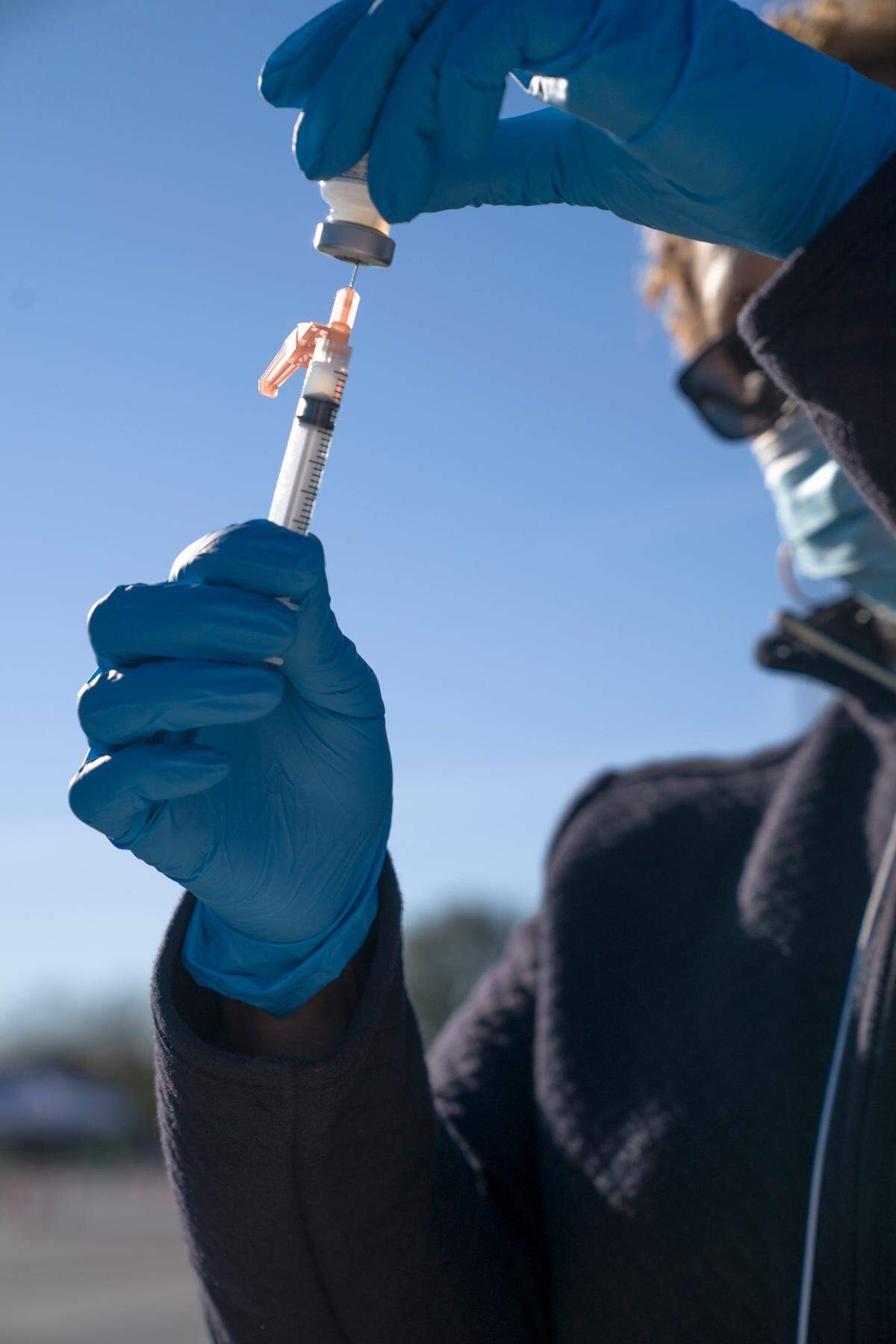 A healthcare worker prepares a syringe of the Moderna COVID-19 vaccine at the Civic Center in Columbus, Ga. on Saturday, Jan. 23, 2021.