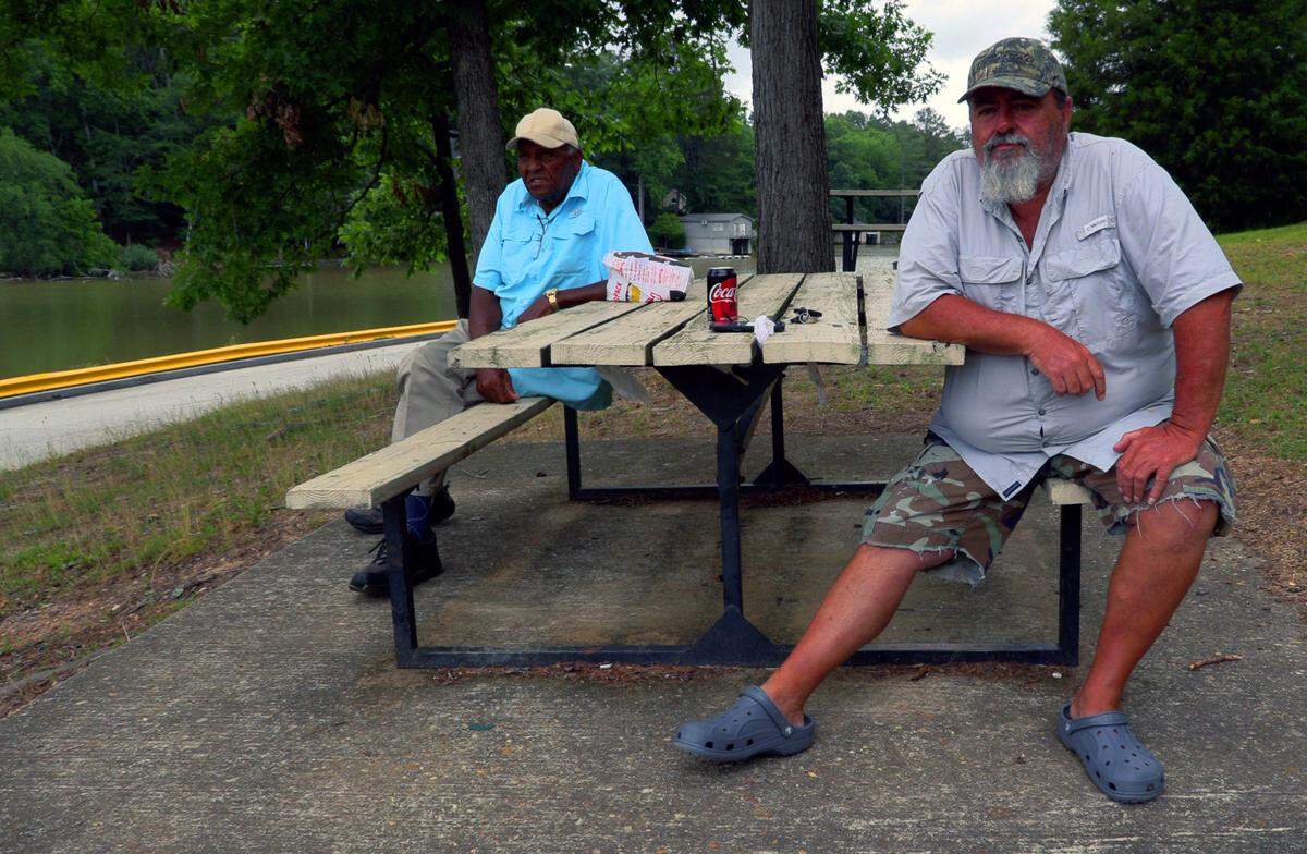 Robert Martin, left, and Mark Guillaume share observations on what the Lake Oliver Marina in Columbus, Georgia has been like during the coronavirus pandemic. The marina had a soft reopening Monday. Several services they provided that had been suspended because of the coronavirus pandemic have resumed, albeit modified to adhere to current safety and social distance guidelines.