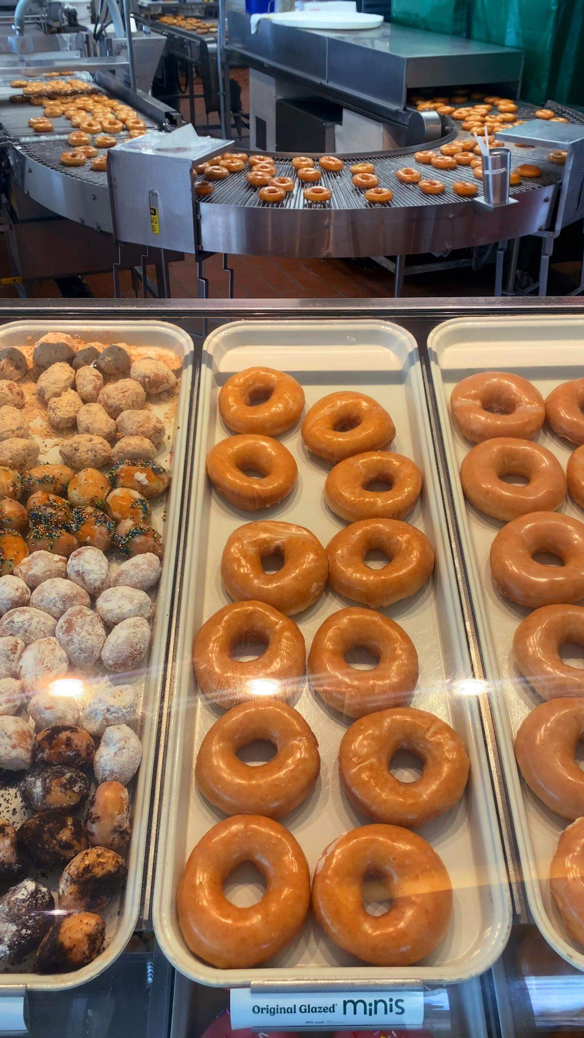 Customers can watch fresh, hot glazed donuts come off the line at Krispy Kreme, 6761 Veterans Parkway, in Columbus. 06/04/2025