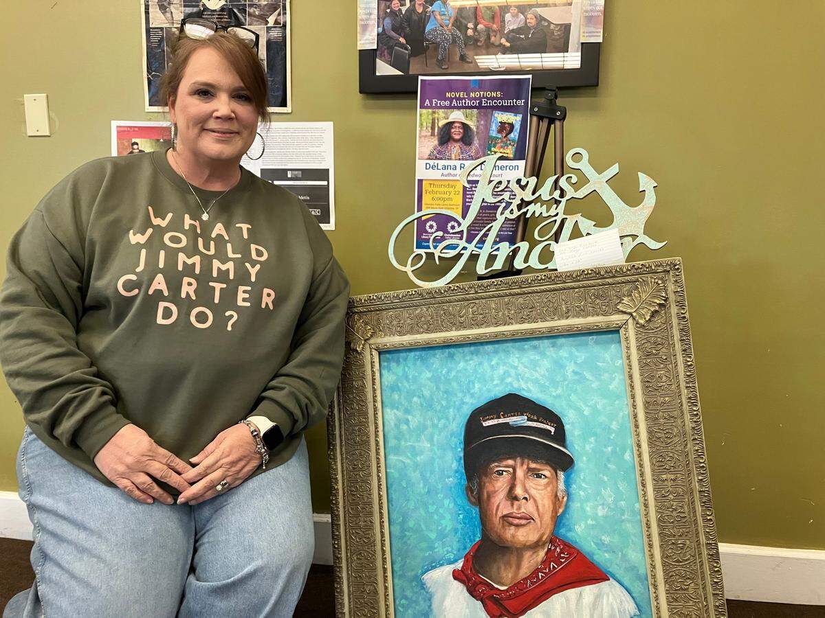 Tiffany Patten of Columbus poses next to a portrait of former President Jimmy Carter at Bonita’s Restaurant in Plains, Georgia, on Jan. 9, 2025, the final day of Carter’s six-day state funeral.