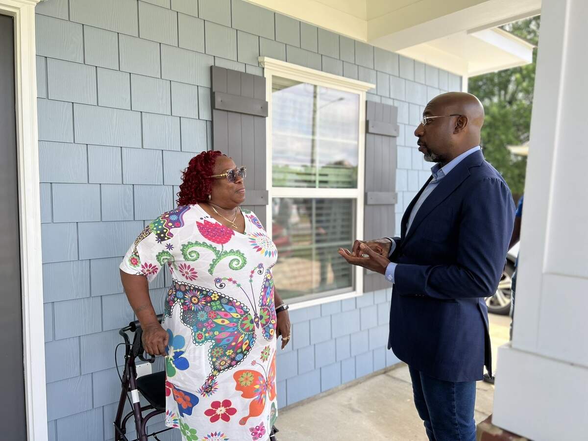 U.S. Sen. Raphael Warnock (D-Ga.) speaks to Columbus resident Vera Adams during his July 6, 2026, tour of Elliott’s Walk and sites of upcoming developments in Columbus. Warnock helped secure $4.3 million in funding for affordable housing projects by NeighborWorks Columbus and the Housing Authority of Columbus.