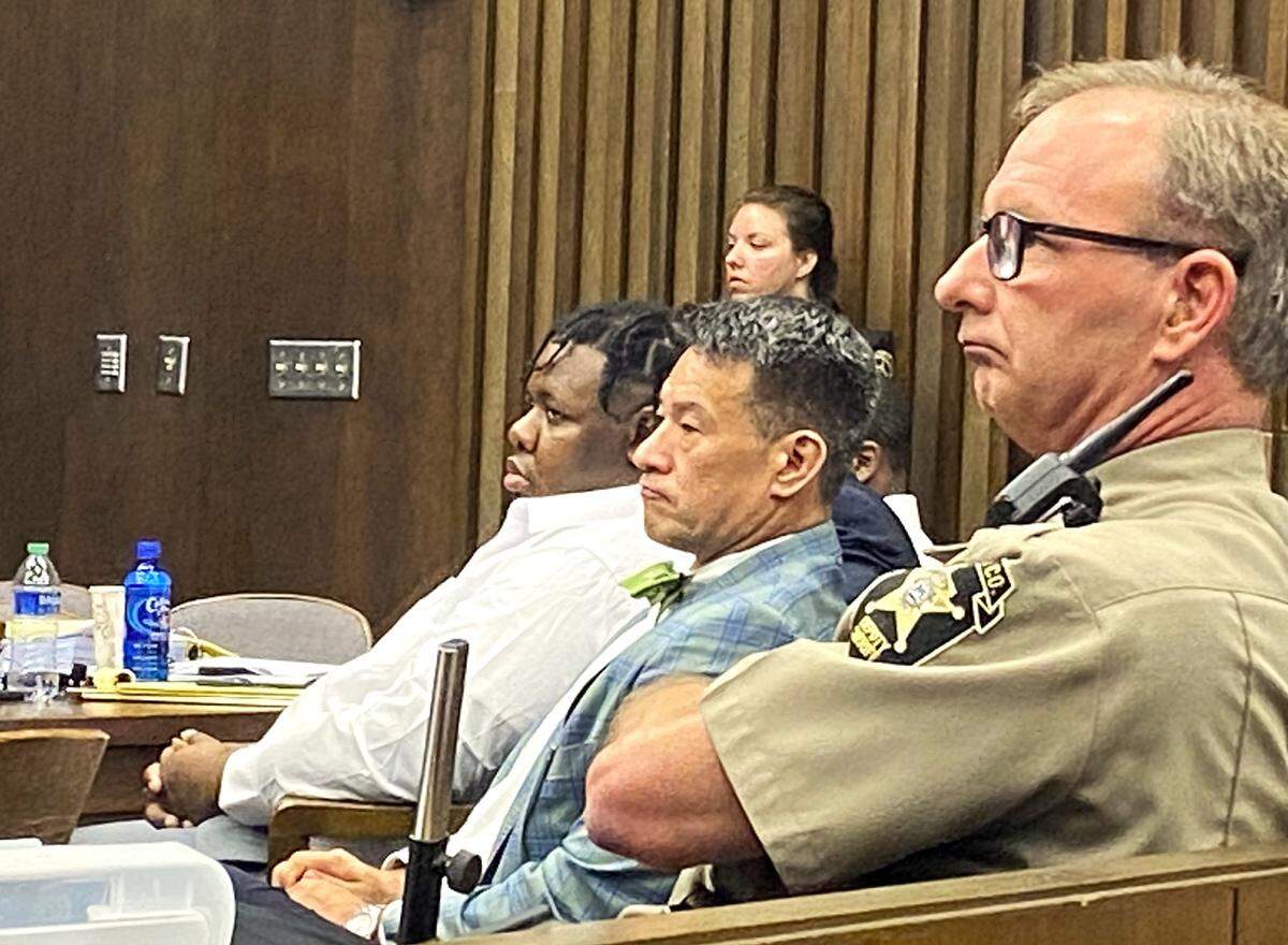 Defendant Rodderick Glanton and attorney Allen Jones listen to testimony beside a sheriff’s deputy during a gang-related Columbus murder trial.