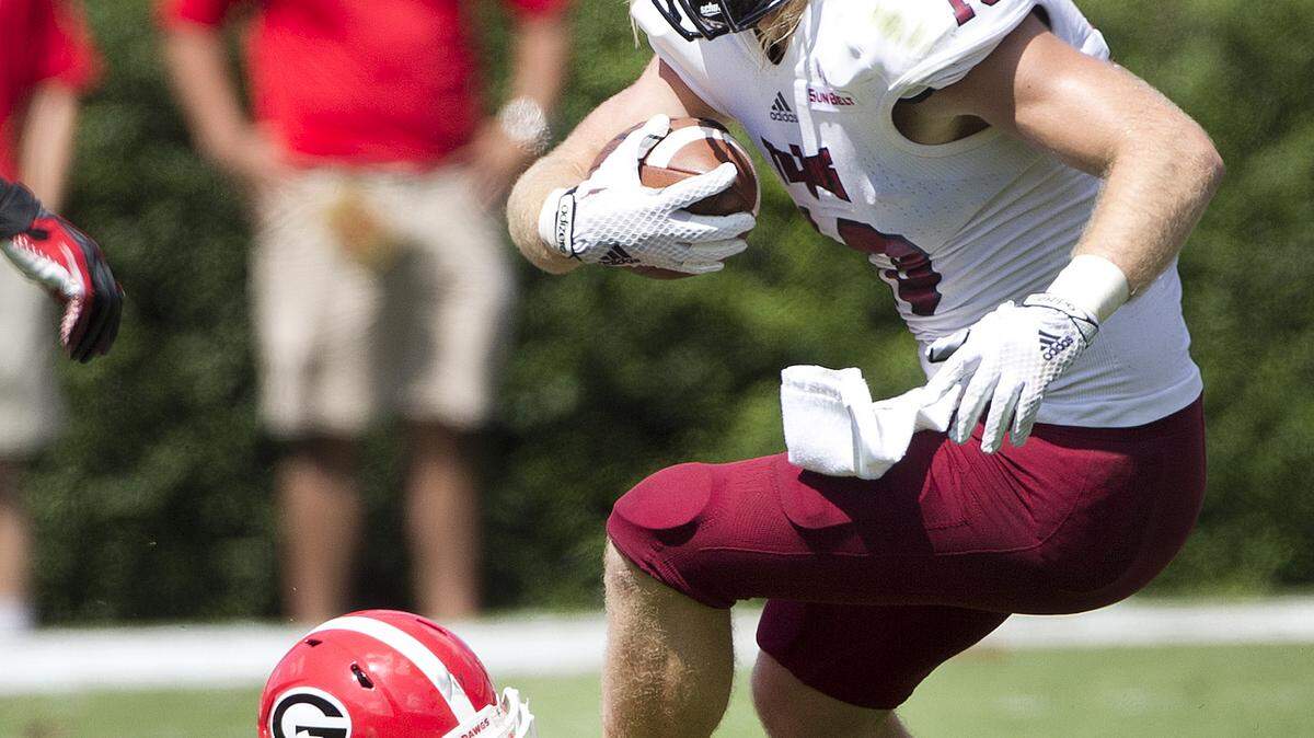 Troy wide receiver K.D. Edenfield (13) tries to escape from the grasp of Georgia defensive back Malkom Parrish (14) in the first half of an NCAA college football game, Saturday, Sept. 20, 2014, in Athens, Ga. Georgia won 66-0. (AP Photo/John Bazemore)