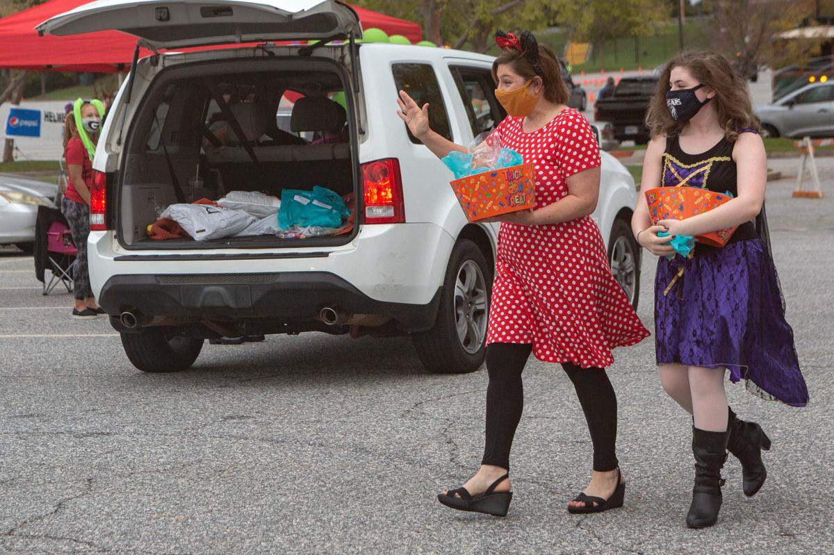 A mother-and-daughter pair, Briget and Reagan Markwood represent Rotary International as they pass out candy to cars at the Spooktacular Trunk or Treat event on Sunday, Oct. 25, 2020 at the Civic Center in Columbus.