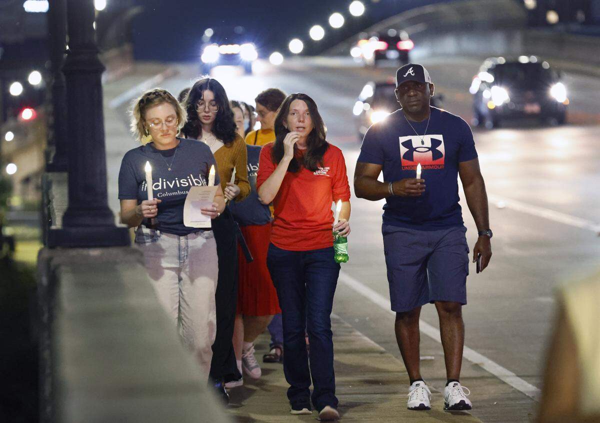 People gather Sept. 4, 2025, on the 13th Street Bridge, which connects Columbus, Georgia, to Phenix City, Alabama, for a candlelight vigil to remember and honor victims of gun violence. The event was organized by Phenix City Indivisible, Columbus, GA Indivisible and the Under the Muscadine Catholic Worker community.