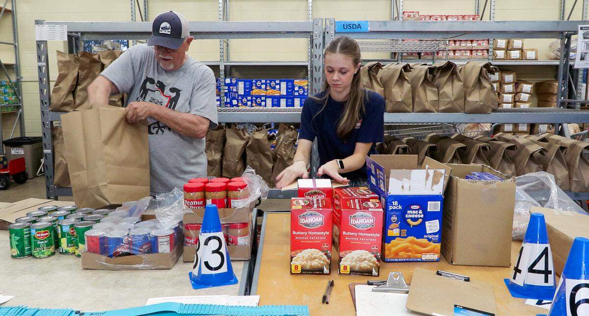 Volunteers at St. Anne Outreach in Columbus prepare bags of food March 11, 2026, for a food distribution.
