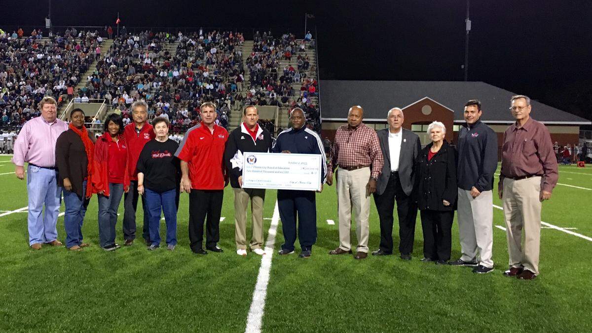 LARA BETH JOHNS/Phenix City Public Schools 
 The Phenix City Council presented a $200,000 check to the Phenix City Board of Education at Friday night's Central High School football game in Garrett-Harrison Stadium. Pictured from left are board members Rick Carpenter, Zara Parham, Mesha Patrick, Paul Stamp and Fran Ellis, superintendent Randy Wilkes, board president Brad Baker, Mayor Eddie Lowe, councilors Arthur Day, Jim Cannon and Gail Head, Mayor Pro-Tem Chris Blackshear and city chief financial officer Steve Smith.