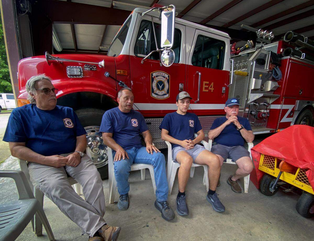 From left, Cataula volunteer firefighters Carl McCluskey, Paul Price, Hunter Price and Tim Ryan talk May 7, 2026, about their roles in assisting with the massive wildfire in Brantley County, Georgia.