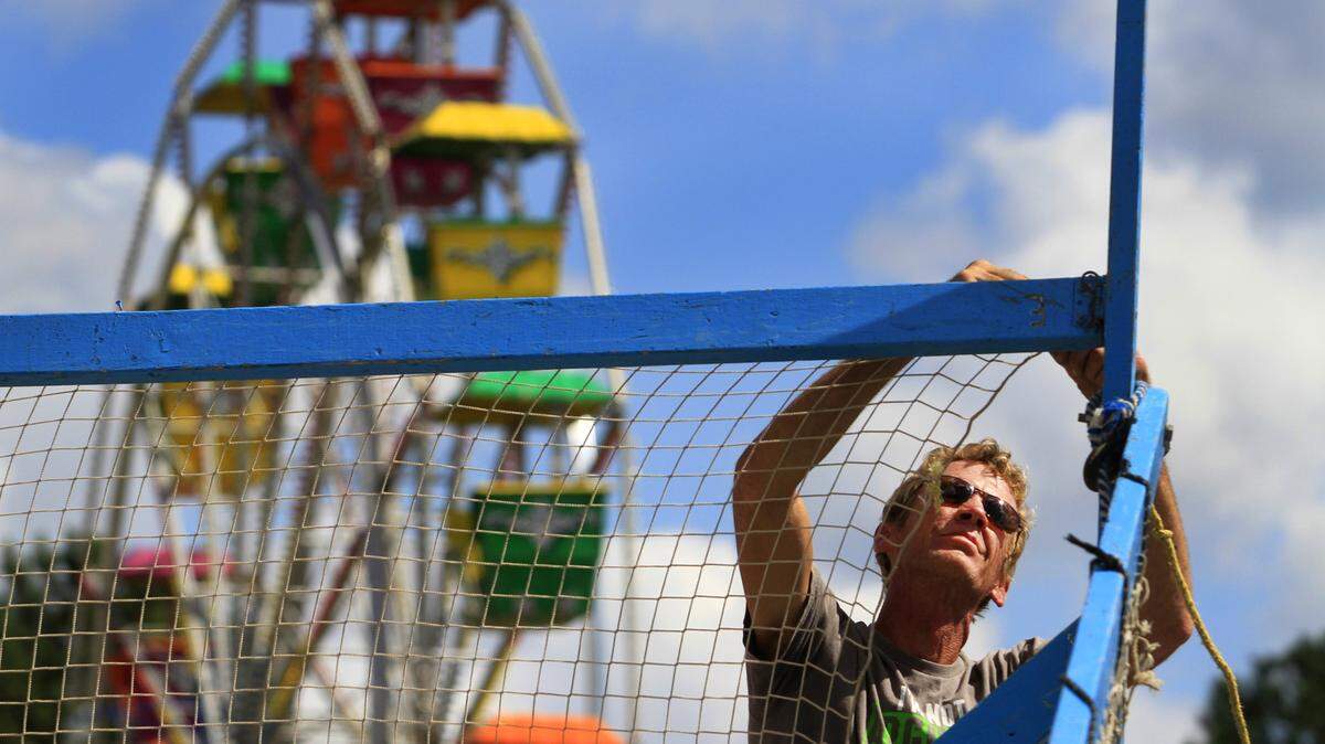 Photos by Mike Haskey/mhaskey@ledger-enquirer.comMike Ludwick attaches netting to the wooden frame of a carnival game Monday afternoon on the grounds of the Columbus Civic Center in preparation for the opening day of the Greater Columbus Fair.