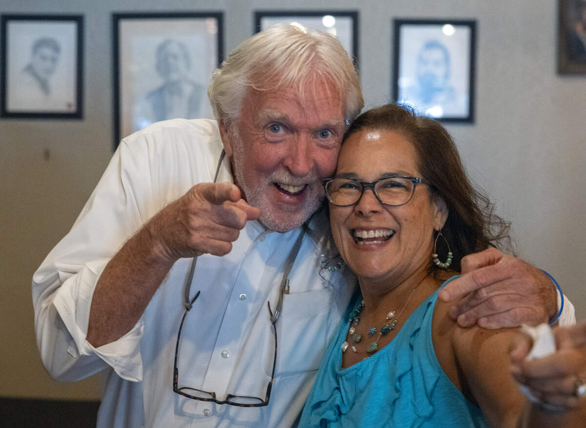 “Theo of Golden” author Allen Levi, left, posed for photos with several people during a visit to Fountain City Coffee in Columbus on June 25, 2026.